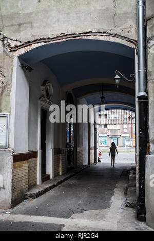 Frauen in der Silhouette in einer bogenförmigen Gasse mit zerfallenden Altbau Stockfoto
