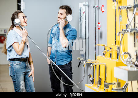 Ein junges Paar, das Spaß Auswahl Wasserhahn Dusche in der Nähe der Schaufenster der Sanitär Shop Stockfoto