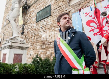 Der Bürgermeister von Florenz Dario Nardella mit bürgermeisterlicher Schärpe während einer öffentlichen Zeremonie. Hinter ihm, den Palazzo Vecchio. Stockfoto