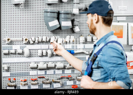 Stattliche workman Wahl wasser Rohre und Rohrverbindungen stehen in der Nähe der Vitrine im Sanitär Shop Stockfoto