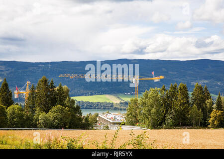 Landschaft mit Bergen, Fluss und Bau kran in Lillehammer, Norwegen. Stockfoto