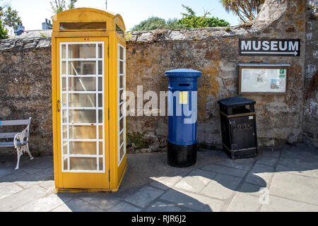 Telefon Box und Briefkasten durch das Museum Eingang, oben auf der High Street, St Anne's, Alderney. Stockfoto