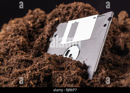 Die Diskette ist halb in die Erde eingegraben. Stockfoto