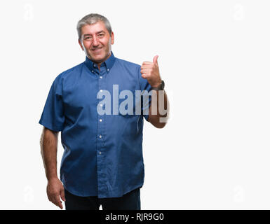 Gut aussehender älterer Mann über isolierte Hintergrund lächelnd mit glücklichen Gesicht und zeigt auf die Seite mit dem Daumen nach oben. Stockfoto