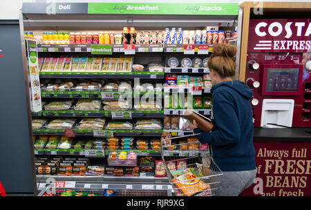 Eine Frau, die Geschäfte für Takeaway Mittag essen in einem Supermarkt Store in Großbritannien. Stockfoto