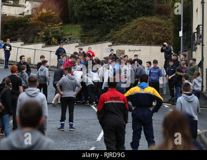 Boys tussle für den Lederball in einer Seitenstraße während der jährlichen "Fastern's E'en Hand Ba" Veranstaltung auf Jedburgh's High Street in den Scottish Borders. Stockfoto