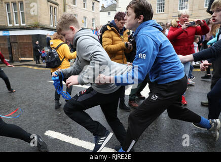 Boys tussle für den Lederball während der jährlichen "Fastern's E'en Hand Ba" Veranstaltung auf Jedburgh High Street in den Scottish Borders. Stockfoto