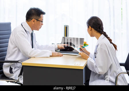 Zwei Ärzte im Krankenhaus die Diagnos des Patienten besprechen Stockfoto