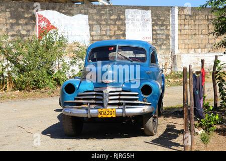 BARACOA, Kuba - 12. Februar: Menschen laufen durch Oldtimer Auto am Februar 12, 2011 in Baracoa, Kuba. Letzte Änderung im Gesetz erlaubt die Kubaner Autos zu Handel ein Stockfoto