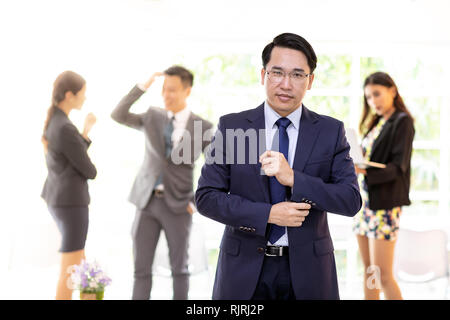 Portrait von asiatische Geschäftsmann mit Business Team im Hintergrund bei Office Fenster mit für Coporate arbeiten Hintergrund Stockfoto