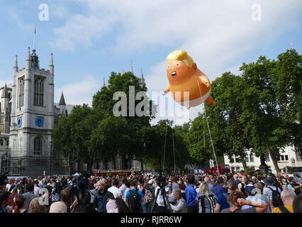 Während eines offiziellen Besuchs in Großbritannien von dem Präsidenten der Vereinigten Staaten von Amerika Donald Trump, einem aufblasbaren Karikatur von Trump war im Protest gegen ihn geflogen. Der Ballon war über Parliament Square, London, am 13. Juli 2018 geflogen. Der 6-Meter (20 ft) hoch, Helium - Kunststoff aufblasbare gefüllt, auch bezeichnet als "Ballon" oder "Blimp", wurde von Matt Bonner entworfen und stellen Sie sich vor, Schlauchboote von Leicester gebaut. Stockfoto