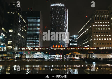 London, Großbritannien - 26 Januar, 2019: DLR-Zug passiert vor moderne Gebäude in Canary Wharf. Canary Wharf ist einer geschäftigen Finanzviertel von London, der oft Stockfoto