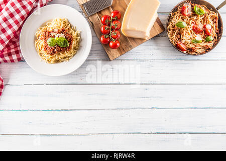 Top der italienischen Pasta Spaghetti Bolognese in der Platte und Pfanne mit Tomaten und Basilikum Stockfoto