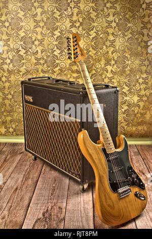 Deutschland. 25 Apr, 2016. Eine ursprüngliche, alte VOX AC30 Gitarrenverstärker von Jmi (Jennings Musikinstrumente aus den 60er Jahren mit einer Fender Stratocaster E-Gitarre aus den 60er Jahren in einer retro Einstellung mit Holzdielen und Muster Tapete. | Verwendung der weltweiten Kredit: dpa/Alamy leben Nachrichten Stockfoto