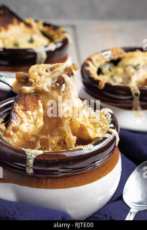 Französische Zwiebelsuppe mit Käse ziehen Stockfoto