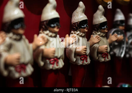 Kleine Puppen mit Hut und Maske des venezianischen Karnevals. Karneval in Italien. Industrielle Keramik Stockfoto