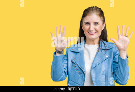 Schöne, reife Frau mittleren Alters tragen Mode Leder Jacke über isolierte Hintergrund angezeigt und zeigen mit den Fingern Nummer zehn, während Smilin Stockfoto