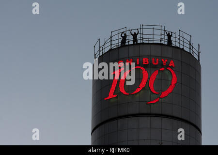 Arbeiter in Silhouette auf dem ikonischen Shibuya 109 Turm in Shibuya, Tokio, Japan. Stockfoto