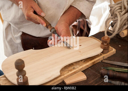 Geigenbauer arbeiten an der Schaffung eines Saiteninstrument. Er benutzt einen Meißel oben zu schnitzen. Stockfoto