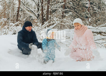 Wandern Familie mit einem Kind. Familie Spaziergänge in der Natur im Winter. Familie Winter Spaziergang in der Natur. Viel Schnee. Verschneiten Wald. Stockfoto