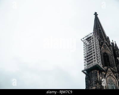 Minimalistische Schuß des gotischen Kölner Dom in Deutschland mit Gerüst gegen bewölkter Himmel Stockfoto