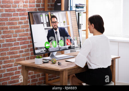 Ansicht der Rückseite des Geschäftsfrau auf Computer mit weißen leeren Bildschirm auf hölzernen Schreibtisch Stockfoto