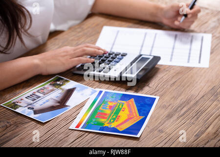 Nahaufnahme einer Person die Berechnung der Wärmeverluste und die Energieeffizienz eines Hauses Stockfoto