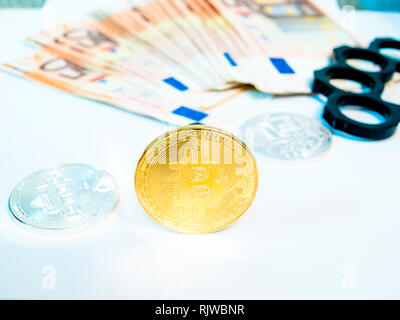 Nahaufnahme von bitcoin, Euro, Bügeleisen Knöchel Knöchel - duster der Kriminalität und der Stapel Papier euro Banknote. Europäisches Geld Währung nominale fünfzig Euro. Stockfoto