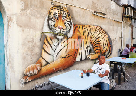 Street Art Wandbild durch Farbe Fighter gemalt, das einen Tiger in Ruhelage, an einer kleinen Gasse in Chulia Street, Georgetown, Penang, Malaysia Stockfoto