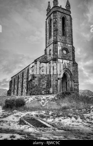 Dies ist ein Moody schwarz-weiß Foto von den Ruinen von dunlewy Kirche an der Basis der Errigal Mountain in Donegal Irland. Es gibt ein Grab umgedreht Stockfoto