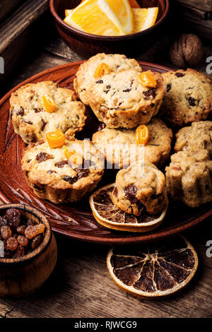 Gebackene Plätzchen mit Rosinen und orange auf rustikalen Holztisch Stockfoto