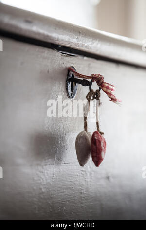 Vintage Schlüssel im Kofferraum mit paar Stoff Herz im kühlen Licht hängen Stockfoto
