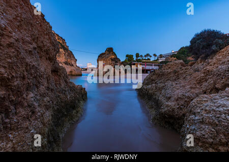 Durch die Felsformationen in Richtung Meer und klaren Himmel bei Sonnenuntergang, Alvor, Algarve, Portugal, Europa Stockfoto