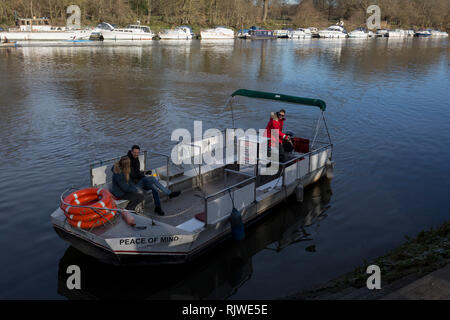 Zwei Passagiere auf hammerton's Ferry, überqueren den Fluss Themse zwischen Marble Hill House am nördlichen Ufer, Ham am südlichen Ufer, am 3. Februar 2019 in London, England. Hammertons Fähre wurde ursprünglich im Jahre 1908 von Walter Hammerton und den jetzigen Besitzern geöffnet sind Herr und Frau Francis Spencer im Juli 2003. Die ganze Familie sind derzeit in allen Aspekten des Geschäfts beteiligt, aber der tägliche Betrieb der Fähre wird von Vater und Sohn, Francis & Andrew Spencer. Hammerton's ist ein Fußgänger- und Zyklus Fähre über den Fluss Themse im Londoner Bezirk Richmond upon Thames, London Stockfoto