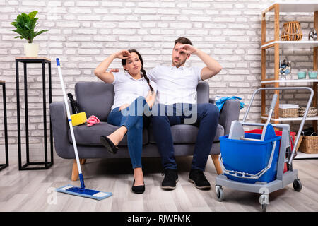 Porträt der jungen Müde Paar auf dem Sofa zu Hause sitzen Stockfoto