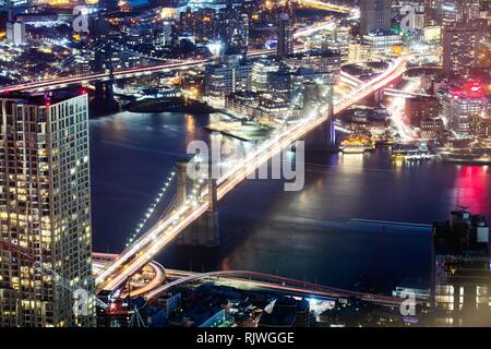 In New York City Brooklyn Bridge und die Skyline von Manhattan bei Nacht beleuchtet Stockfoto