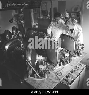 Fernsehen in den 1950er Jahren. Ein Mann mit einem frühen Fernsehen in der Produktion oder die Prüfung an der Elfo Unternehmen eingestellt ist das Experimentieren mit der Fernsehtechnik. November 1959 Stockfoto