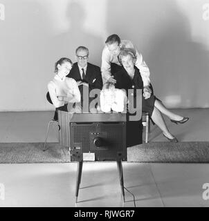 Fernsehen in den 1950er Jahren. Familie vor einem Fernseher und durch das neue Medium Fernsehen fasziniert im März 1959. Schweden Stockfoto