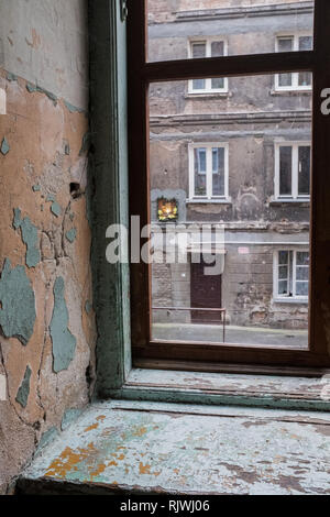 Bildnis der Jungfrau Maria in einer Wand in einem Mietshaus in Warschau, wie durch ein Fenster zu sehen Stockfoto