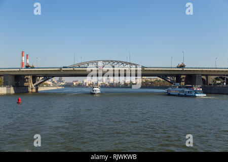 Moskau, Russland - 21. September 2014: Touristische Fähre auf der Moskwa. Gebäude entlang der Ufer, Trail Bridge im Hintergrund. Stockfoto