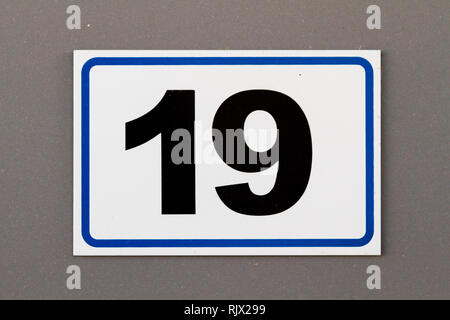 Nummer 19 (19) in Schwarz auf weißem platic Platte auf einem Haus Stockfoto