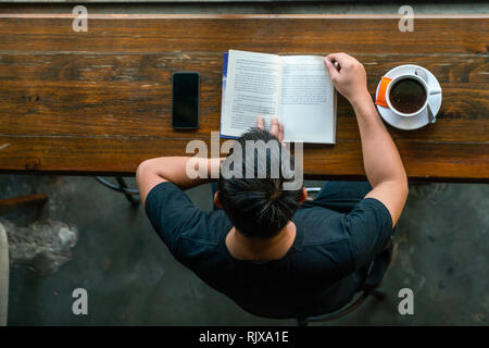 Hohe Betrachtungswinkel des Menschen lesen Buch Stockfoto