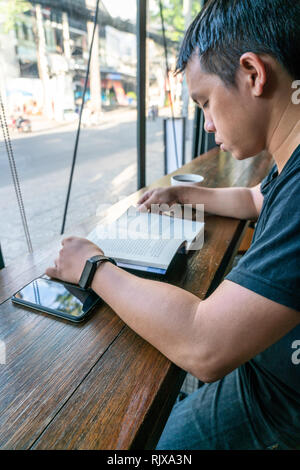 Seitenansicht des asiatischer Mann ein Buch lesen. Stockfoto
