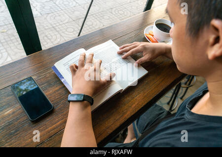 Mann lesen Buch im Cafe Stockfoto