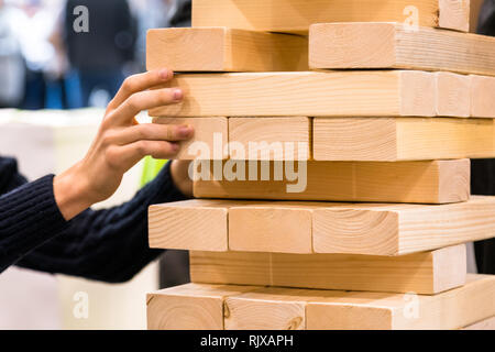 Hochhaus, der Mensch als Holz nehmen Sie Teil der hölzernen Turm. Planung, Risiko und Strategie im Business Konzept Stockfoto