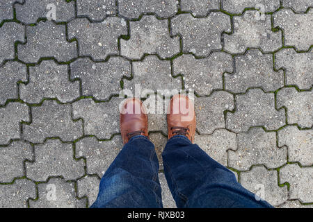 Beine von oben stehen auf dem Gehweg Stockfoto