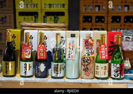 Eine Sammlung von bunten sake Flaschen auf Anzeige im Shop in Hida Furukawa, Präfektur Gifu, Honshu, Japan Stockfoto