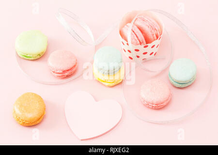 Bunte Makronen mit der leeren Herzen Form beachten und das silberne Band Stockfoto