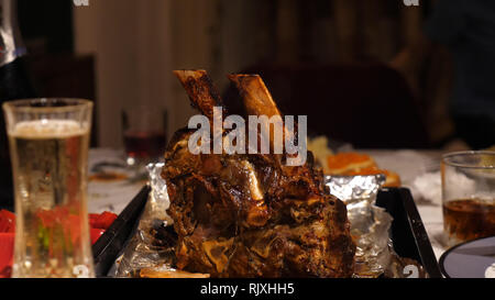 Männliche Hände, die Messer und schneiden Rindfleisch Rippe Braten auf Tisch Stockfoto