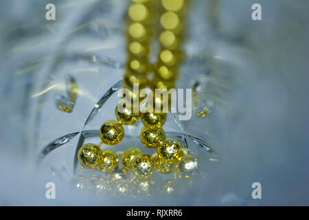 Makro Kunst Abstrakte schöne defokussierten Kristallglas mit goldfarbenen Mardi Gras Perlen und Bokeh Stockfoto
